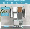 A multi-tiered drying rack with various clothing and towels displayed on it, set against a light gray tiled wall. Náhľad obrázku produktu