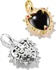 Two heart-shaped charms, one gold with black stone and gems, the other silver with intricate filigree. Anteprima dell’immagine prodotto