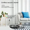 A cordless vacuum cleaner is shown charging next to a sofa and plants. Produktbild-Vorschau
