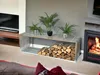 A living room scene with a fireplace, a TV, and a firewood rack. Produktbild-Vorschau