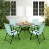A patio set with four chairs and a table is arranged on a green lawn in front of a white house with windows. Produktbild-Vorschau