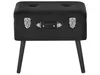 A black ottoman designed to look like a vintage suitcase, with four dark legs. Náhled obrázku produktu