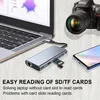 A laptop, a docking station, a camera, and a smartphone are arranged on a wooden surface. Produktbild-Vorschau