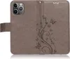 A gray flip case for an iPhone 13 Pro Max with a floral and butterfly embossed design. Produktbild-Vorschau