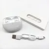 A white wireless earbud charging case with earbuds inside, along with a charging cable and a box of ear tips, are laid out on a white surface. Produktbild-Vorschau