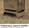Close-up of a portable camping wood stove's base on dry grass. Náhled obrázku produktu