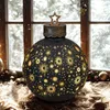 A large, decorative Christmas ornament with a star pattern is placed on a surface in front of a window with snow outside. Produktbild-Vorschau