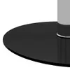 A close-up view of the base of a table, showing the black circular tabletop and a silver metallic rim around the base of the table leg. Náhled obrázku produktu