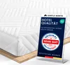 A close-up of a white mattress topper with a marketing display card in front of it. Produktbild-Vorschau