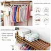 A bamboo clothing rack with various garments hanging on it, and a separate section showing storage options. Voir les images du produit