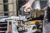 A person is using a cordless jigsaw to cut a copper pipe. Podgląd zdjęcia produktu