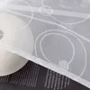 A close-up of a white fabric with a circular pattern, partially covering a black surface with text. Produktbild-Vorschau