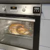 A roasted turkey is being cooked in an oven, with a digital thermometer attached to the oven door. Náhľad obrázku produktu