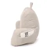 A beige corduroy backrest pillow with armrests, designed for reading, watching TV, or relaxing. A small book is tucked into a side pocket. Náhľad obrázku produktu