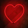 A red neon heart-shaped lamp is mounted on a wooden wall. Voir les images du produit