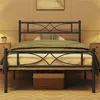 A black metal bed frame with a green comforter and a patterned pillow is shown in a bedroom setting. Produktbild-Vorschau