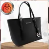 A black leather tote bag is displayed on a wooden stand against a white and light gray background. Produktbild-Vorschau