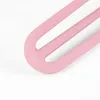 Close-up of the curved end of three pink, metal hairpin legs on a white background. Podgląd zdjęcia produktu