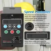 A close-up view of a black speed controller with various buttons and a digital display, set against a blurred background showing electrical equipment and a yellow hard hat. Náhľad obrázku produktu