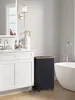 A modern bathroom with a vanity, bathtub, and a black laundry hamper with wheels. Náhled obrázku produktu