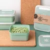 A collection of green food storage containers, one filled with peas, arranged on cork coasters. Náhľad obrázku produktu