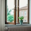 A smart home window sensor is attached to an open window, with a houseplant on the windowsill and a radiator below. Anteprima dell’immagine prodotto