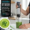 A person is using an immersion blender to mix a green smoothie in a glass beaker, with a bowl of green soup in the foreground. Produktbild-Vorschau