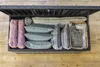 An open storage box filled with cushions and blankets. Produktbild-Vorschau