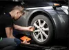 A man is using a portable jump starter unit to inflate a car tire. Náhled obrázku produktu