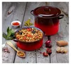 A rustic kitchen scene with a pot of chickpea stew and a larger pot with a lid, surrounded by ingredients like garlic, peppers, onion, and bread. Podgląd zdjęcia produktu
