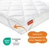 A white quilted mattress topper with elastic straps shown on a mattress. Produktbild-Vorschau