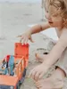 A child playing with a toy car and trailer on the beach. Náhľad obrázku produktu