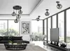 A modern living room with a black leather sofa, a glass coffee table, a large TV, and multiple pendant lights. Produktbild-Vorschau