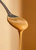 A spoon filled with almond butter, with a drip falling from it. Produktbild-Vorschau