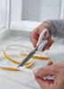 A person's hands are cutting a strip of foam sealing tape with scissors. Náhľad obrázku produktu