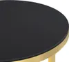 A close-up view of the edge of a round table with a black surface and a gold trim. Podgląd zdjęcia produktu