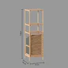 A tall, narrow bamboo shelf unit with a louvered door at the bottom and a grey fabric basket on the side. Dimensions are indicated with text and lines. Produktbild-Vorschau