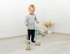 A young boy is playing with wooden toys in a room. Anteprima dell’immagine prodotto
