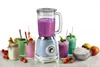 A vintage-style blue blender is shown in the center, surrounded by colorful smoothies, a jar of ingredients, and a bowl of crushed ice. Fresh fruits like strawberries and apples are scattered around the base. Anteprima dell’immagine prodotto