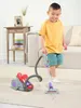 A young boy is playing with a toy vacuum cleaner in a living room. Produktbild-Vorschau