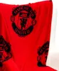 A red fleece blanket with the Manchester United logo is draped over a white chair. Náhľad obrázku produktu