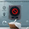 A wall-mounted laundry dryer with a red prohibition sign on its screen, next to icons representing peace of mind and energy saving, and a basket of clean laundry below. Produktbild-Vorschau