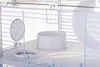 Close-up view of a white plastic and metal hamster cage interior, showing a food bowl and a ventilation disc. Anteprima dell’immagine prodotto