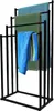 A black metal towel rack with four arms, holding three towels of different colors. Produktbild-Vorschau