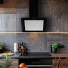 A modern kitchen countertop with a black range hood, induction cooktop, and various kitchen items. Produktbild-Vorschau