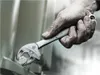 A close-up shot of a person's hand using a WERA 6004 Joker XL Maulschlüssel to tighten a bolt. Voir les images du produit