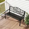 A black metal garden bench with a decorative backrest sits on a wooden deck next to a white railing. Podgląd zdjęcia produktu