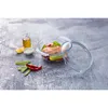 A glass casserole dish filled with salmon and vegetables, with ingredients like oil, lemon, and chili peppers arranged around it on a textured gray surface. Produktbild-Vorschau