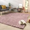 A living room scene with a pink rug, a gray armchair, and decorative items. Produktbild-Vorschau