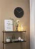 A wall clock and decorative items on a shelf. Produktbild-Vorschau